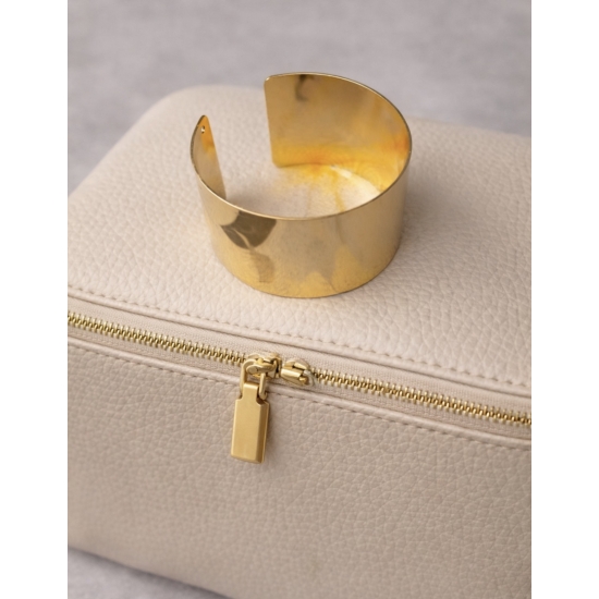 Elegancka, szeroka bransoleta w kolorze złota – minimalistyczny dodatek, który podkreśla kobiecą klasę i styl.